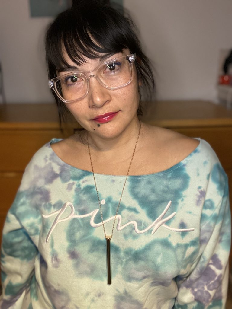 A photo of the author modeling the Crave vibrator-necklace, with a long sleek pendant.